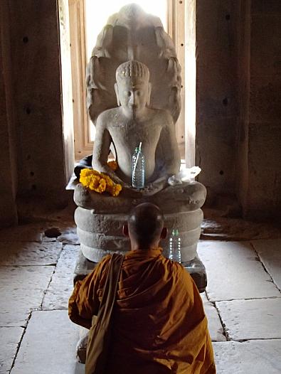 ピマーイ遺跡主塔の内部で仏像に祈りをささげる僧侶。