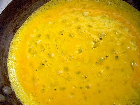 10. 別のフライパンに油を熱し、溶きほぐした卵（２個分）を薄焼き卵を作る要領で流し入れる。
