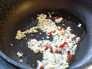 6. フライパンに多めに油を入れ、ニンニクと赤唐辛子を入れて香りが出るまで炒める。 
