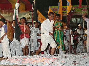 チェンマイで行われるフェスティバルで裸足で火渡りをする信者
