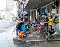 道の角で通行人を待ちかまえ、水を掛ける子供たち