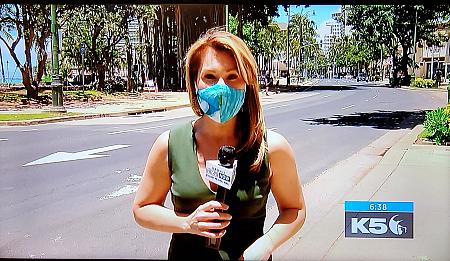 ひと気のないカラカウア大通りからマスク着用でレポートするTVキャスター