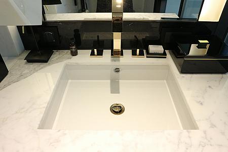 ソファの両横は、お手洗いスペースと、バスルームスペースに分かれています。こちらはお手洗いスペース。白を貴重とした爽やかで清潔なスペースになっています。なんとお手洗いにはウォッシュレットがついています。香港でウォッシュレットがついているホテルって少ないんですよ。これは貴重！
