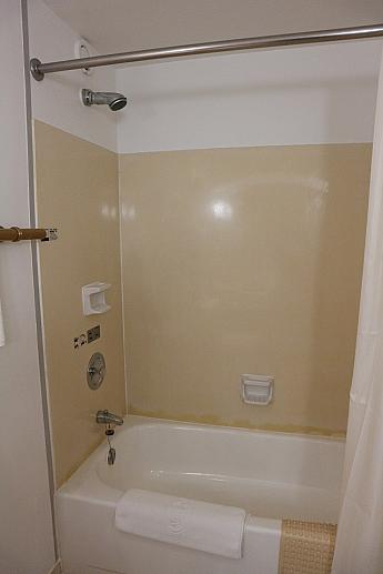 バスルーム内。バスタブと固定式シャワー。