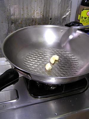 3. フライパンに油を熱し、丸ごとのにんにくをきつね色になるまで香りよく炒めます。