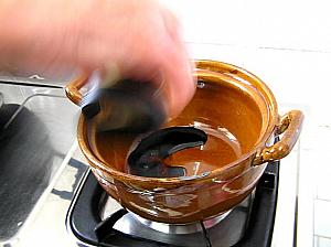 土鍋に生抽と老抽を注ぎ、炒めた豚バラ肉、水を入れ、よく肉とからめておく