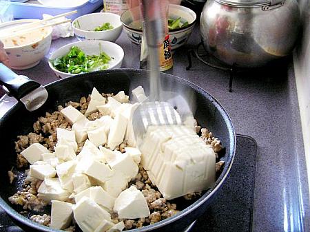 4. 豆腐を切らずにそのまま入れ、フライ返しを使ってさいの目に切る （おーっ、お見事！主婦の知恵！）