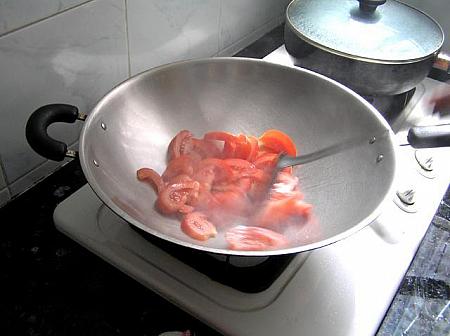 4. フライパンに油を熱し、トマトを炒め、ジュースが出て、しんなりしてきたら、調味料を加える。