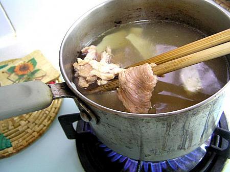4. 鍋にチキンスープと水を沸騰させ、しょうがのスライス、豚肉を入れる。