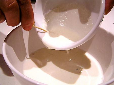 3. 膜がしっかり固まったら、端に楊枝を刺し、穴を開けて中の牛乳を別の器にあける