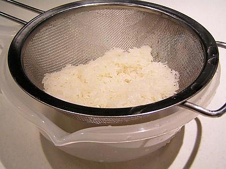 1. お米は通常の洗い方と同じに洗い、ザルで水気を切っておく 
**　水洗いしてから、水につけこまずに炊きます。少し硬いアルデンテに仕上げるのが 美味しい煲仔飯のコツです。
