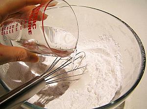 3.ボールにふるった粉類をいれ、そこへゆっくり水（80ｍｌ程度）を加えて溶いておく<br>
4. 鍋に残りの水を入れ、火にかけ沸騰したら、グラニュー糖または片糖を加えて煮溶かす
