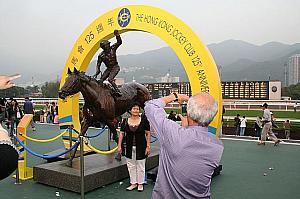 香港の伝説的名馬、サイレントウィットネスの銅像の前で記念撮影する人