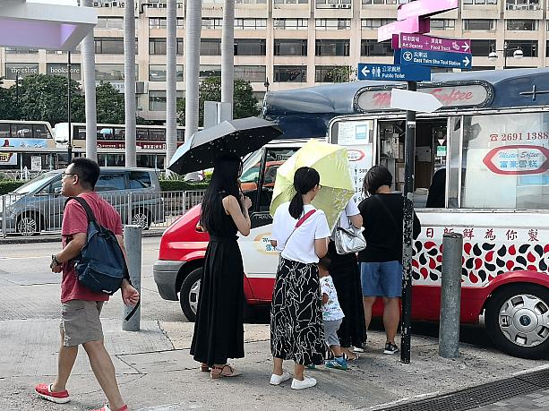 こんな日はやっぱりアイスクリームが恋しい～♪並んでいる女性は傘で日よけ。