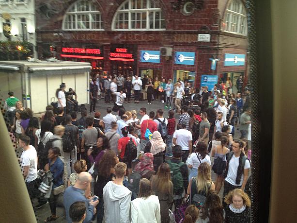 オックスフォード・サーカスの駅の前、大道芸人を群衆が取り囲んでいます
