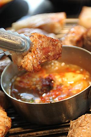 テーブルで焼きあがったお肉にメルチョッ（カタクチイワシの塩辛）をつけて、お好みでサンチュにのっけて