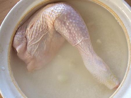 ２．よく洗った鶏肉にお湯をかけて、１．に酒・ニンニクと一緒に入れる。
