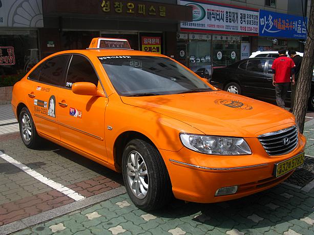 おおっと、ハデなオレンジ色のタクシーが！？コレは外国人が言葉の心配ナシに乗れる「インターナショナルタクシー」なんです！来月1日から本格稼動を開始する予定ですが、今日はナビ社の近くに偶然このタクシーが止まっているのを発見しました～！