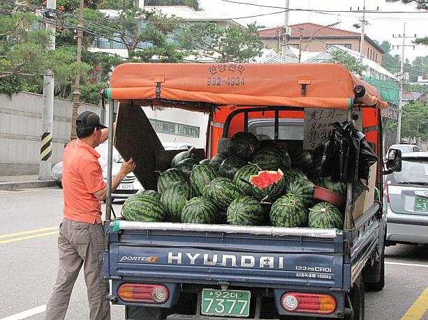 わっ立派なスイカ！8000ウォンは安いかも？！割ってあるのは 、味見用かな？<BR>果物類はいつの季節も街角のいたるところで売られています。