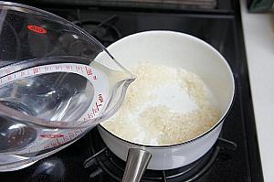 ⑤ お米にごま油が回ったら、水を加える。