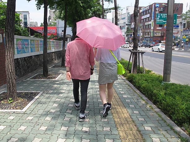 ピンクのシャツと傘、蛍光イエローのバッグという目がチカチカするようなスタイルのカップル。