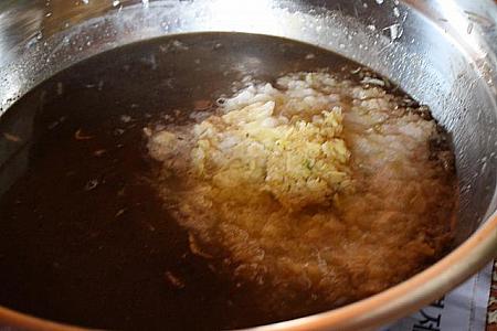 ダシスープがさめたら、もち米を煮出したものを投入して、たまねぎやニンニク、生姜のすったものを大量に入れます。
