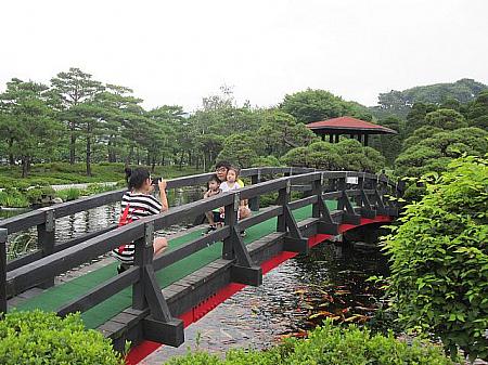 日本庭園を感じさせる赤と茶色の木製の橋