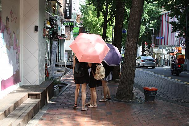 あれ？雨が降ってる？日差し除けに雨傘をさす女子大生が！