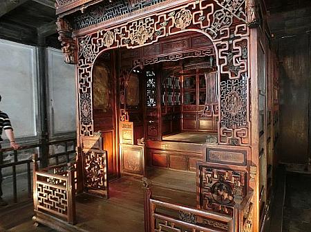 彫刻の施された工芸品のベッドが古民家内に展示されています