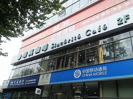 お店の隣のビルには銀行、携帯電話会社（中国移動通信）、カフェ、フィットネスクラブ（健身）などが入っています。