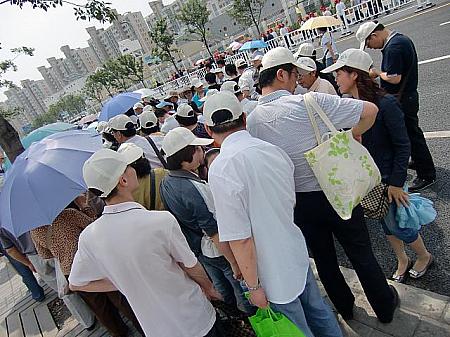 中国の地方からのツアー客。帽子と傘は必須。