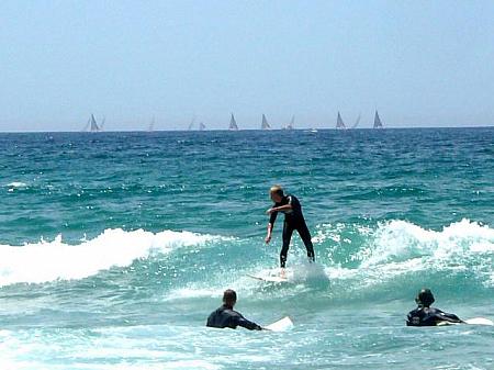 ＜海にはサーファーがいっぱい。サーフィンレッスンは、初心者でも丁寧に教えてくれます。＞