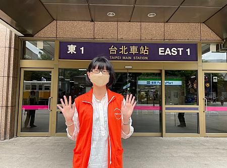 ナルワントツアーのオレンジ色のジャケットを着たガイドが<b>台北駅「東一門」入口の内側</b>でお待ちしております！