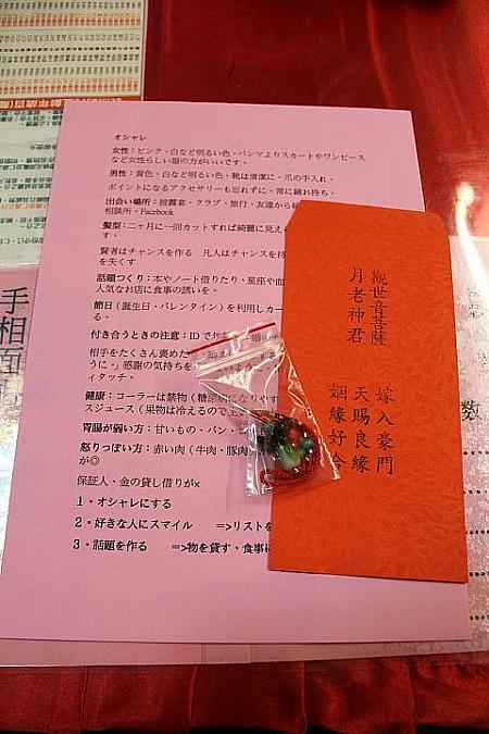 龍山寺でもらえる運命の赤い糸を入れる封筒、白菜のお守り、モテテクニックを書いた紙をセットでプレゼント
