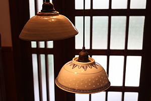 サイズも柄も異なる茶碗が照明に変身！玄関のタイルは当時のものを再利用しているそうです。