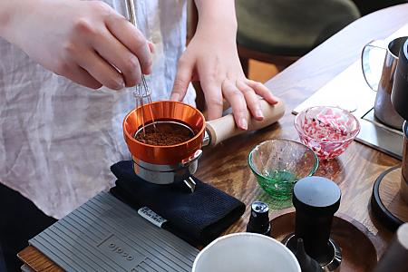 挽いたコーヒー豆を特別な道具で混ぜて均一化させてからマシンへON！　