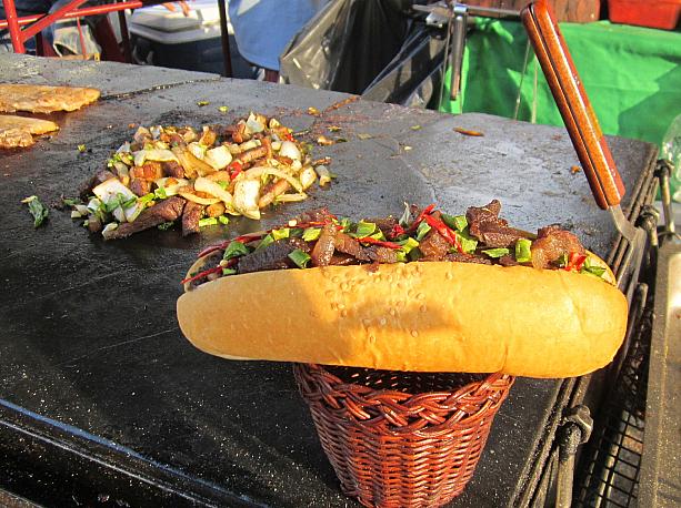 会場の周りではグッズや原住民グルメの屋台が。ナビは焼き肉ホットドッグに挑戦。美味しい～。