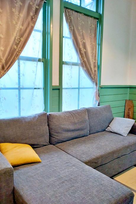 エメラルドグリーンの木枠の窓に、畳に、ソファー。和洋折衷がいい感じです。