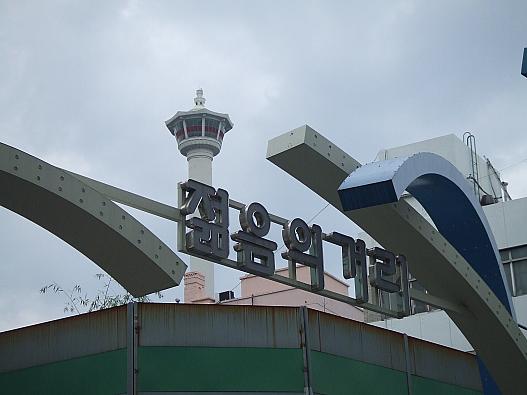 「チョルムメ コリ」からすぐ　　角のスーパーは改築中？　　建物がないため龍頭山公園の釜山タワーが顔をのぞかせてます(^^)