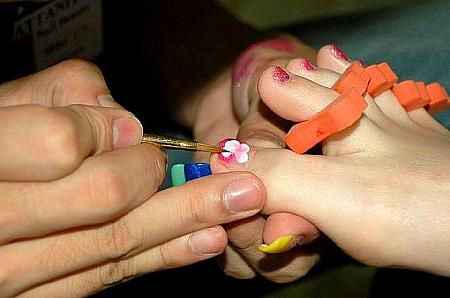 グラデーションされた爪の上に、ラインストーンも使って花を作成しました。スワルスキー・クリスタルが使われています。 
