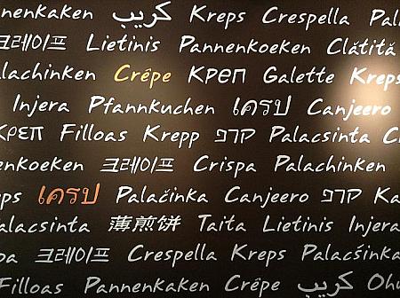 黒塗りの壁には多言語で書かれたクレープの文字