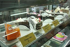 店内には、ブラウニー：４５バーツなど「アジアのケーキです！」といわんばかりの色鮮やかなケーキが陳列するショーケースもあり。