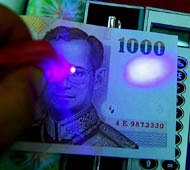偽1,000バーツ札にご注意！ -ブラックライトでチェック中