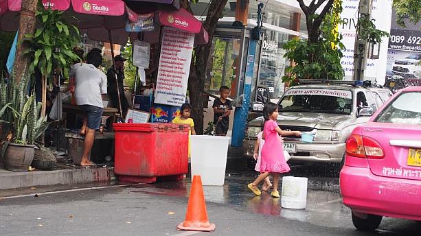 バケツから水を汲んで通りすぎる車に水を掛ける子供たちも。。