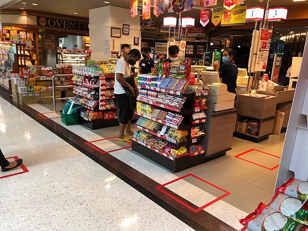 スーパーのレジでは、並ぶ場所の目印として床に赤いテープが貼られています。レジに並ぶ時に、前後の人と距離を取れるようになっています。