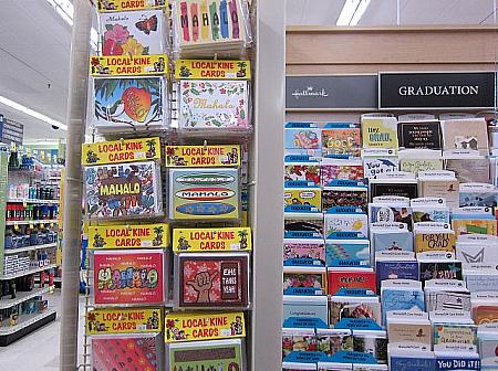 英語のグリーティングカードの横で存在を主張するハワイ語のカード。ドラッグストア店内で。