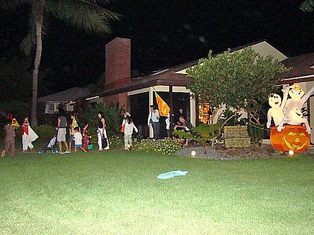 ハロウィーン当夜、住宅街を巡る子供たちと付き添いの親

