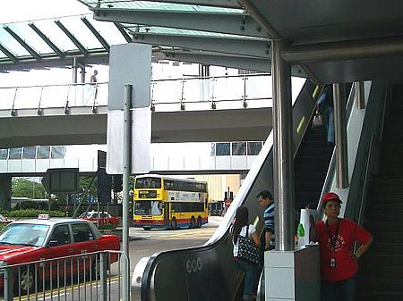 MTR港島線　中環（セントラル）駅　A出口をあがり、すぐ隣にあるエスカレーターで高架へ上がります。