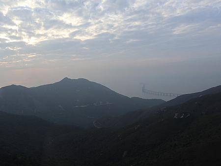 山あいの遠くに橋が浮かんでいるのは見えますか？あれが2018年に開通した、香港とマカオを結ぶ橋です。