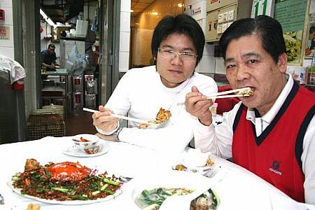 が、しかし切り抜きも数あれど、オーナーの廖喜さんが自ら蟹を食べている写真は香港ナビだけなのだ！しかも親子二代で。今度来た時はきっとこの記事がパウチッコして壁に貼ってあるはずですから、ナビを見て喜記に行った人は探してみてね。
